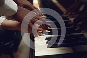 Black grand piano player hands on the keys