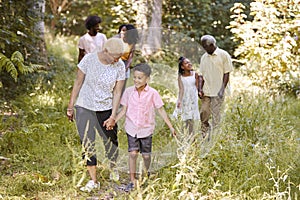 Black grandma walking with grandson and family, full length