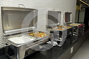 Black granite counter tops with food that will be served at the wedding anniversary dinner for the guests.