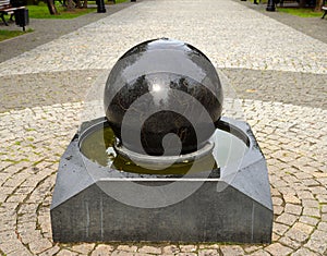 Black granite globe fountain with the outlines of continents on Ushakov Boulevard, Rybinsk, Yaroslavl region, Russia