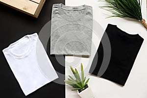 Black , gray , white t-shirts with wood box and cactus. rustic background photo