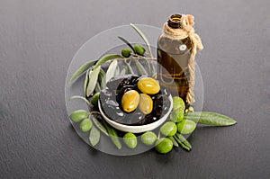 Black and green olives mixed in the porcelain bowl and Virgin olive oil