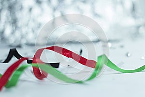 Black, green, red, white ribbons with bokeh background