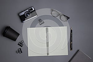 Black and grey working items with notebook, coffee cup and glasses