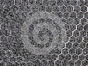 Black grit, gravel or shack caught in white plastic honeycomb