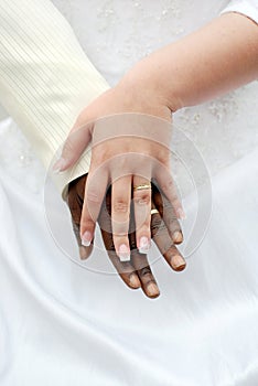 Black groom and white fiance hands with rings