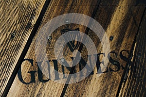 Black Guinness beer logo on rustic weathered wood