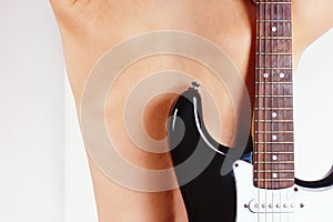 Black guitar on the background of naked female back