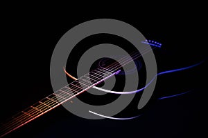 Black guitar on a dark background under beam of colored light with copy space. guitar music low-key concept diagonal projection