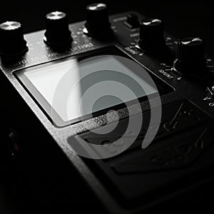 Black guitar effects pedal with multiple knobs and a digital screen. The knobs are