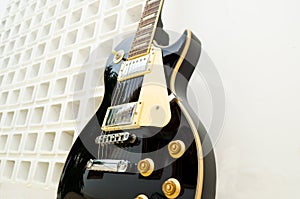 Black guitar model les paul on a white background part white and part full of holes