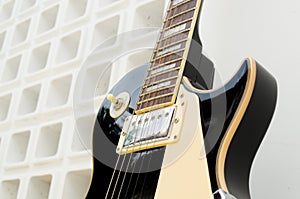 Black guitar model les paul on a white background part white and part full of holes