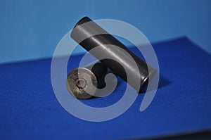 a black gun with the barrel facing towards the camera on a blue background