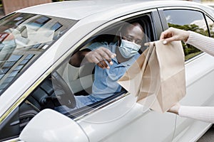 Black guy driver in face mask taking take away food