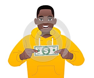 A black guy is holding a dollar bill in his hands. A handsome African boy in a yellow hoodie with pocket money. A happy