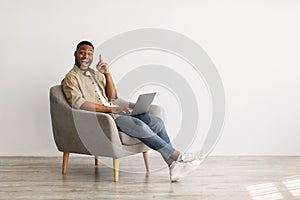 Black Guy With Laptop Having Idea Sitting In Chair Indoor