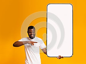 Black guy pointing at white empty smartphone screen