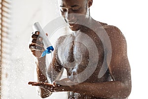 Black Guy Pouring Shampoo On Hand Washing Hair In Shower