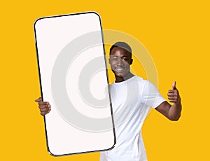 Black guy showing big white empty smartphone screen and like