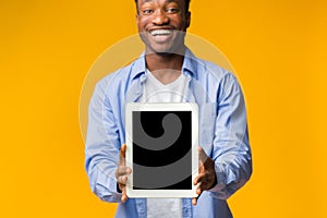 Black Guy Showing Blank Tablet Screen On Yellow Background, Mockup