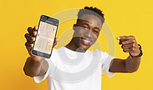 Black Guy Showing Phone With Mobile Navigation App, Yellow Background