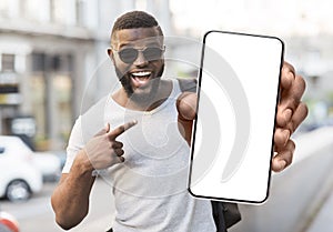 Black guy showing white empty smartphone screen, closeup