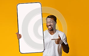 Black guy showing white empty smartphone screen, closeup