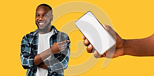 Black guy showing white empty smartphone screen, closeup