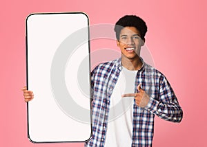 Black guy showing white empty smartphone screen, closeup