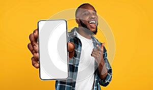 Black guy showing white empty smartphone screen, closeup