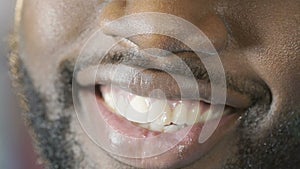 Black guy smiling to camera with charming smile, white teeth, super close-up