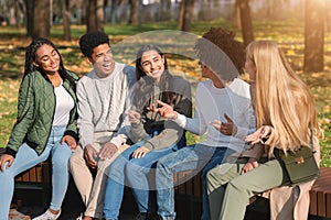 Black guy telling his teen friends funny stories photo