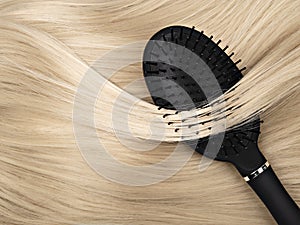 Black hair brush and blond hair.