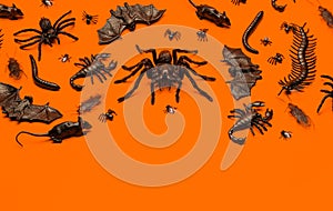 Black Halloween creepy crawly bugs and spiders on orange background with blank space
