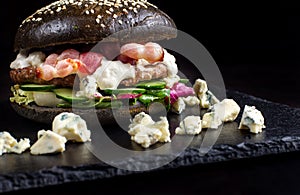 Black hamburger made from beef, with dor-blu.