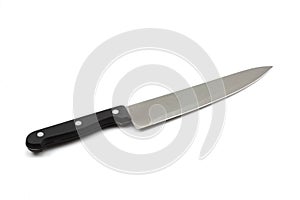 Black handled chef`s knife close up against a white background