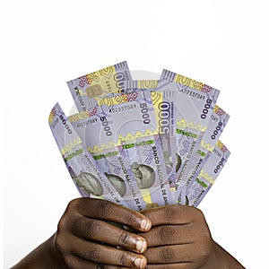 Black hands holding 3D rendered 5000 Angolan kwanza notes. closeup of Hands holding Angolan currency notes