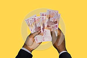 Black Hands in suit holding 3D rendered CFA Franc notes photo