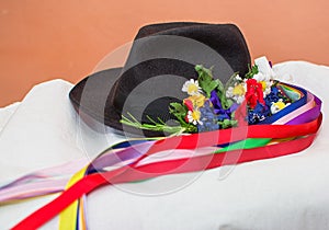 The black hat with ribbons and flowers.