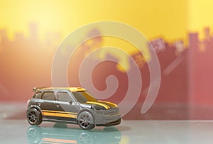 Black hatchback car toy selective focus on blur city background