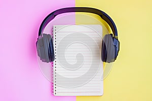 Black Headphone ,Eyeglasses,Notebook and Black pencil on pink and yellow background
