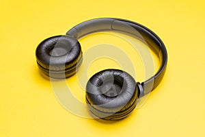 Black headphones . From above . Yellow background. Copy space