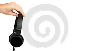 Black headphones in hand isolated on white background. copy space, template