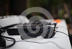 Black headphones and professional mixing console on table.