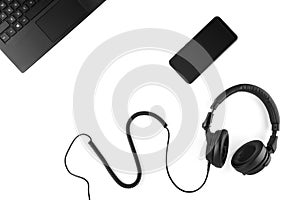 Black headphones, smartphone and laptop on a white background