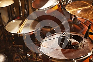 Black Headphones on Studio Drums. Beautiful Closeup Concept Recording Studio or Concert Hall Tools. Musical Background