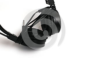 Black headphones with a wire on a white background, jack close-up. Cheap headphones for listening to music