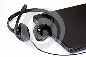 Black Headset And Notebook Computer on White Background