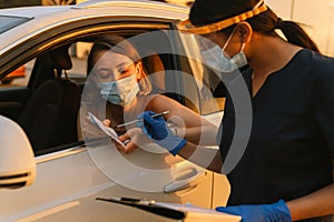 Black health worker wearing protective visors working with woman