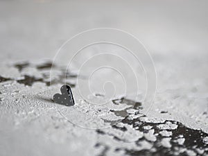 Black heart on a concrete background. Concept of morbidity, sorrow, anxiety, unrequited love, affection